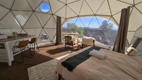a bedroom in a yurt with a large window at Splitrock - Peppertree Ridge Dome in Fallbrook