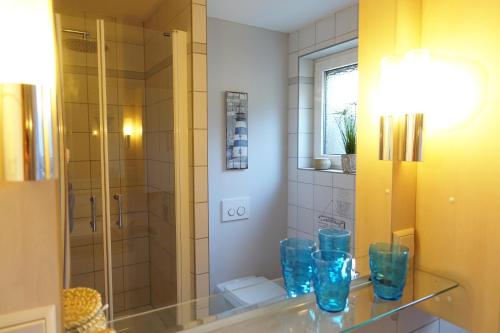 baño con jarrones de cristal azul en una encimera en Meer-Zeit - UG - Seegras, en Kappeln