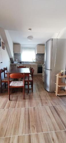 a kitchen with a table and a stainless steel refrigerator at Rigófészek Apartmanház in Gárdony