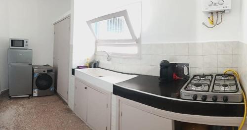 a small kitchen with a stove and a sink at Maison pres plus Grand Bazar d'Afrique Souk El Had in Agadir