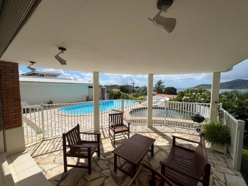 a patio with chairs and a swimming pool at Villa Félix in Le Marin