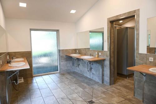 a bathroom with two sinks and two mirrors at Tiny House Pioneer 5 - Green Tiny Spot Friesland in Schortens