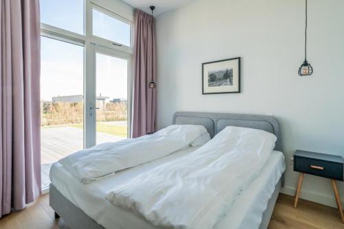 a bedroom with two beds and a large window at Buitenplaats Oudendijke in Ellemeet