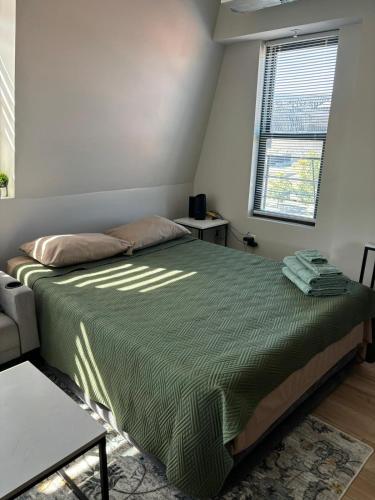 a bedroom with a bed with a green comforter at Modern & Cozy Downtown Apartment in Cincinnati in Cincinnati