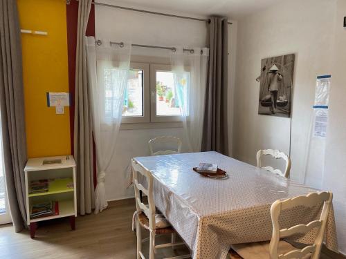 une salle à manger avec une table et des chaises et une fenêtre dans l'établissement Catalunya Les 3 gîtes jardin vue montagne calme T2, à Dorres