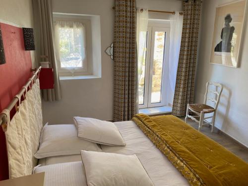 une chambre avec un lit et deux fenêtres dans l'établissement Catalunya Les 3 gîtes jardin vue montagne calme T2, à Dorres