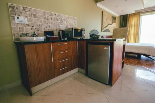 a kitchen with a counter with a sink and a refrigerator at Castellon Boutique Hotel in Table View