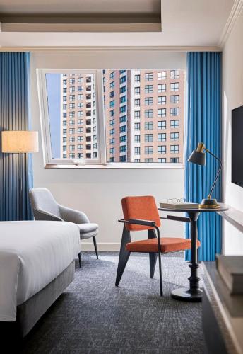 a hotel room with a bed and a chair and a desk at M Village Hotel Thợ Nhuộm in Hanoi