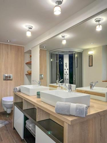 a large bathroom with two sinks and a toilet at Hévíz,Dr Strecker Villa in Hévíz
