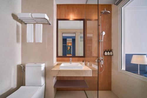 a bathroom with a sink and a mirror at M Village Hotel Thợ Nhuộm in Hanoi