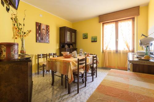 a dining room with a table and a kitchen at Luna Dorata in Selargius