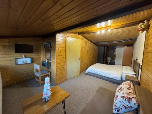 a small room with a bed and a couch at Villa Raiski kyt in Dospat