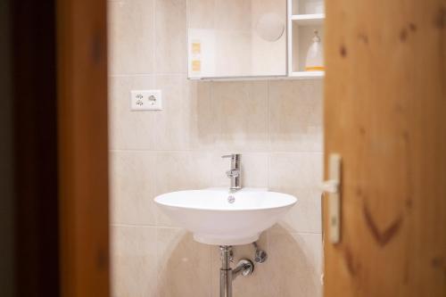 a bathroom with a white sink in a room at Chasa Patgific Studio in Ramosch