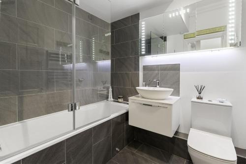 a white bathroom with a sink and a toilet at Manor House Apartment - Indoor Heated Pool, Parking in Torquay