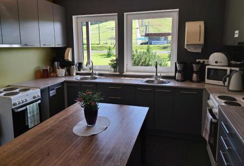 una cucina con un tavolo con un vaso di fiori sopra di Tuhamäe Hostel a Kiviõli