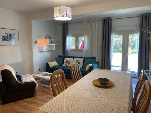 un salon avec une table et un canapé bleu dans l'établissement Maillol Les 3 gîtes joli jardin calme ancien T1, à Dorres