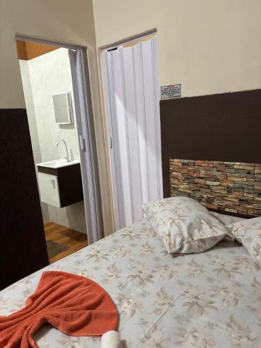 a bed with a towel on it in a bedroom at Pousada Fênix,com piscina -250 METROS DA PRAIA in Pontal do Paraná