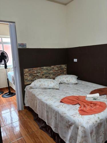 a bedroom with a bed with a red shirt on it at Pousada Fênix,com piscina -250 METROS DA PRAIA in Pontal do Paraná