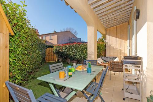 une table et des chaises vertes sur la terrasse dans l'établissement La Petite Grimaud YourHostHelper, à Grimaud