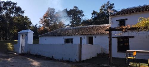 a white house with smoke coming out of it at Cortijo Rural El Contador, con chimenea in Constantina