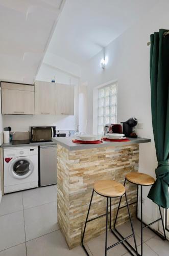 - une cuisine avec un comptoir et deux tabourets dans l'établissement Ancienne bâtisse en plein coeur du port avec clim, à Nice