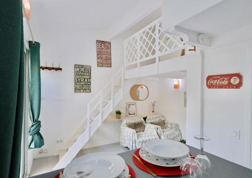 Cette chambre blanche dispose d'un escalier et d'une table. dans l'établissement Ancienne bâtisse en plein coeur du port avec clim, à Nice