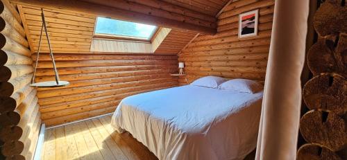 une chambre avec un lit dans une cabane en rondins dans l'établissement Villa D'Andy - Collection Idylliq, à Paron