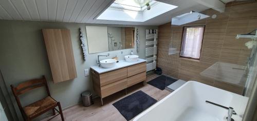 une salle de bain avec une baignoire, un lavabo et un miroir dans l'établissement Villa D'Andy - Collection Idylliq, à Paron