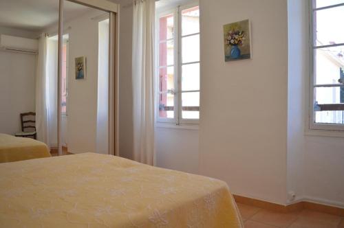 une chambre avec deux lits et deux fenêtres dans l'établissement Appart 2 pièces 4 couchages BANYULS SUR MER BN260-201, à Banyuls-sur-Mer