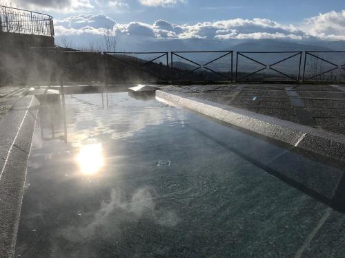un bassin d'eau avec réflexion sur le soleil dans l'établissement Okaido Les 3 gîtes vue montagne jardin ancien T3, à Dorres