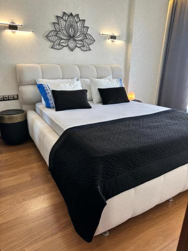 a large bed with a black and white comforter at SABİHA GOKCEN İSTANBUL HOUSES Airport in Istanbul