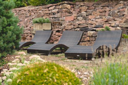 two benches sitting next to a stone wall at Hotel Restaurant Martha in Wertheim