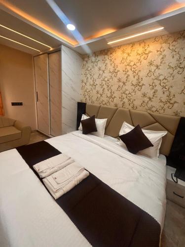 Un dormitorio con una cama grande con sábanas y almohadas blancas. en Hotel RK 75, en Akolia