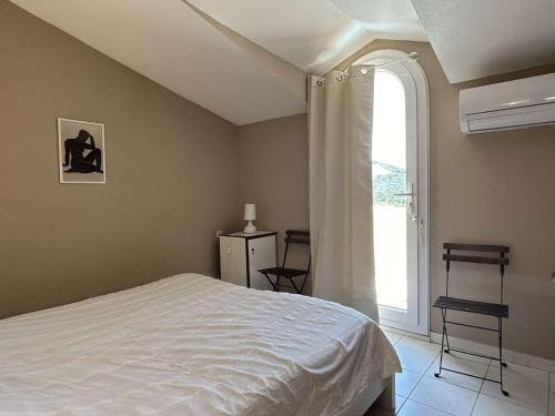 une chambre avec un lit et une grande fenêtre dans l'établissement Appart 3 pièces 5 couchages BANYULS SUR MER BN090-F18, à Banyuls-sur-Mer