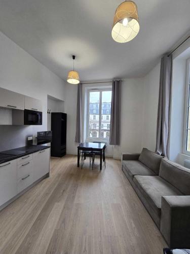 un salon avec un canapé et une table dans l'établissement Studio Grands Boulevards, à Paris