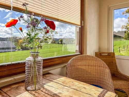 a vase with flowers sitting on a table in front of a window at Haus am Kreuzberg in Medebach