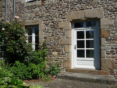 une porte dans un bâtiment en briques avec une fenêtre dans l'établissement Maison typique Normande Mont St Michel, à Isigny-le-Buat