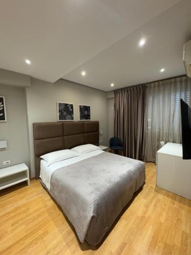 a bedroom with a large bed and a desk at Hotel Oresti Center in Tirana