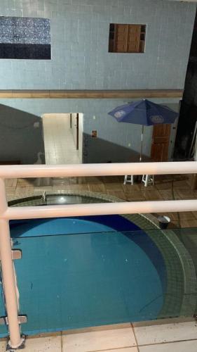 a view of a swimming pool with an umbrella at Pousada e Hostel Camboinha in Cabedelo