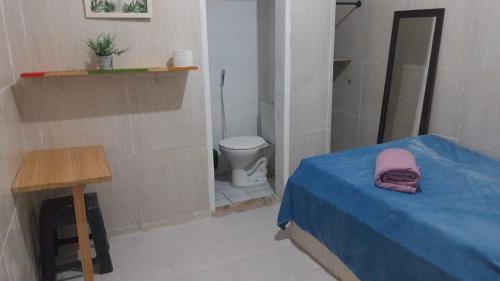 a small room with a bed and a toilet at Pousada e Hostel Camboinha in Cabedelo