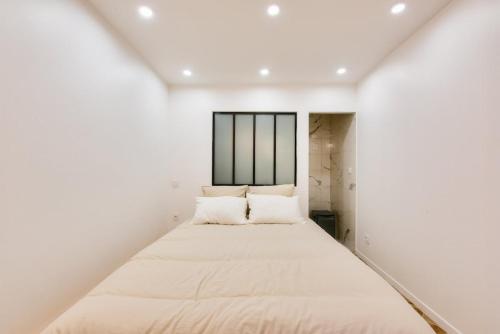Ce lit se trouve dans un dortoir aux murs blancs. dans l'établissement Charming & modern 1BR - Paris 8, à Paris