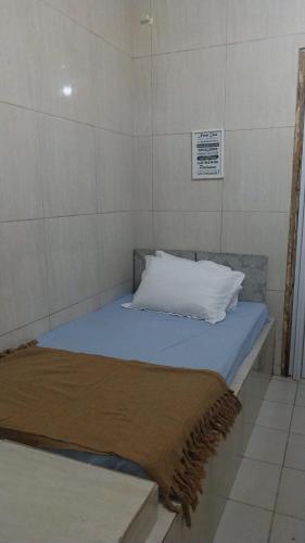 a bed with a pillow and a blanket on it at Pousada e Hostel Camboinha in Cabedelo