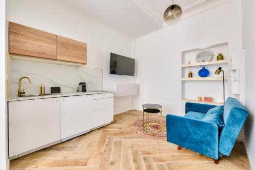 un salon avec un canapé bleu et une cuisine dans l'établissement Charming & modern 1BR - Paris 8, à Paris