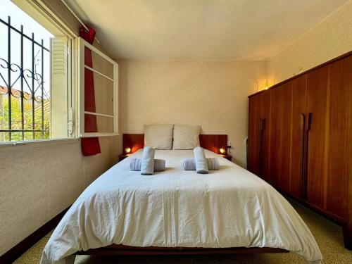 une chambre avec un grand lit blanc avec une fenêtre dans l'établissement Maison Garriga, à Béziers