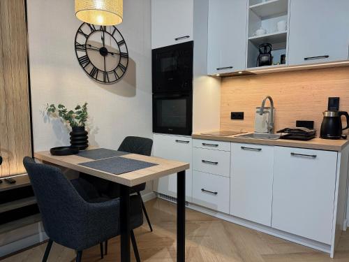 a kitchen with a table and a clock on the wall at Triumph Inn Pension in Rangsdorf