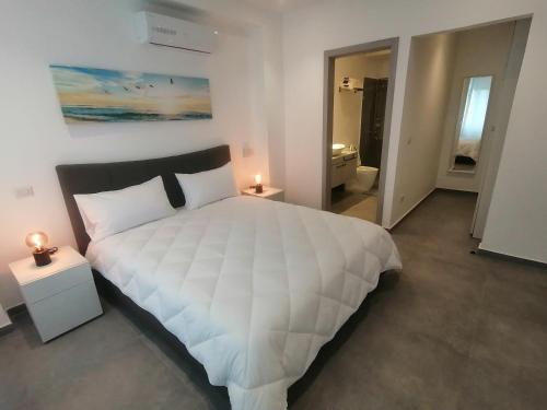 a bedroom with a large white bed and a bathroom at Sabrina Plaza Residence in Las Terrenas