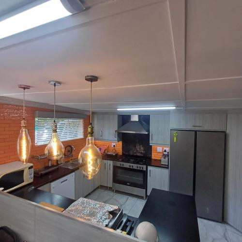 a kitchen with stainless steel appliances and pendant lights at Lavender Lane in Ladysmith