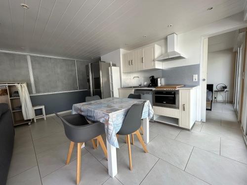 une cuisine et une salle à manger avec une table et des chaises dans l'établissement Spa et Palmeraie Evasion Couples, à Roquebrune-sur Argens