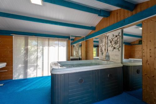 - une salle de bains avec une grande baignoire dans une chambre dotée de sols bleus dans l'établissement Spa et Palmeraie Evasion Couples, à Roquebrune-sur Argens