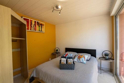 une chambre avec un lit aux murs jaunes dans l'établissement Spa et Palmeraie Evasion Couples, à Roquebrune-sur Argens